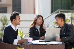 BBA students at a campus activity banner, Texas College of Management and IT