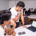 students at the Texas Hackathon debugging the system by looking at the dashboard in laptop